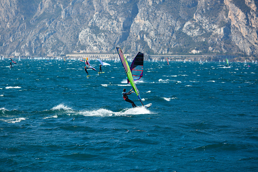 Lake Garda - April 3: windsurfers on the mountain Lake Garda in Italy on the April 3, 2023 . This lake is a famous  place for windsurfers.