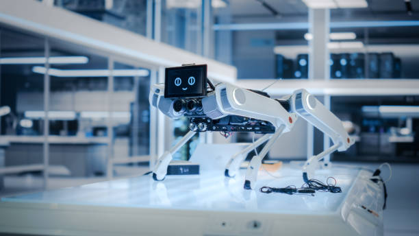 istock High Tech Robot Dog with Lidars, Sensors, Optics, Computers, Cameras, Screen with Running Software Code and Smile Emoji Standing in a Modern Industrial Facility. 1482147567