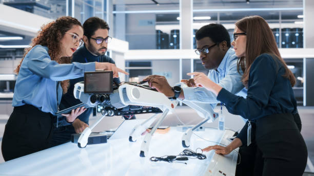 istock Portrait of a Young Team of Multicultural Engineers Use Computers, Connect Microchips, Analyze and Discuss How a Futuristic Robot Dog Works. High Tech Research Laboratory with Modern Equipment. 1482147740