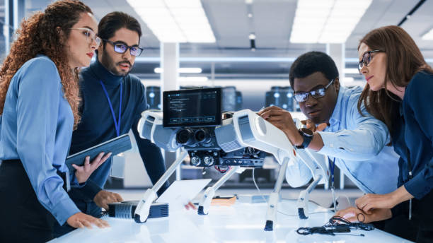 istock Portrait of a Young Team of Multicultural Engineers Use Computers, Insert a Circuit Board, Analyze and Discuss How a Futuristic Robot Dog Works. High Tech Research Laboratory with Modern Equipment. 1482147760