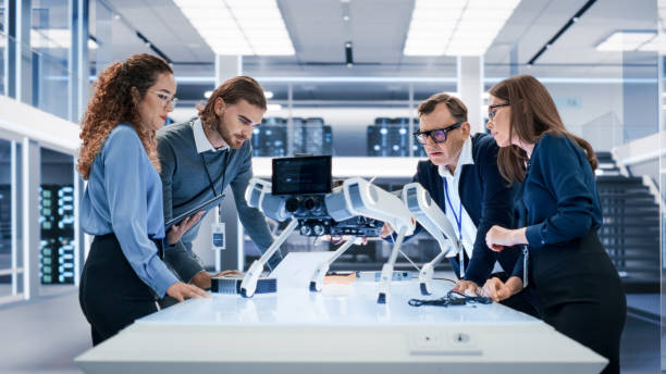 istock Portrait of a Young Team of Multicultural Engineers Use Computers, Insert a Circuit Board, Analyze and Discuss How a Futuristic Robot Dog Works. High Tech Research Laboratory with Modern Equipment. 1482147819