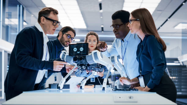 istock Portrait of a Young Team of Multicultural Engineers Use Computers, Insert a Circuit Board, Analyze and Discuss How a Futuristic Robot Dog Works. High Tech Research Laboratory with Modern Equipment. 1482147859