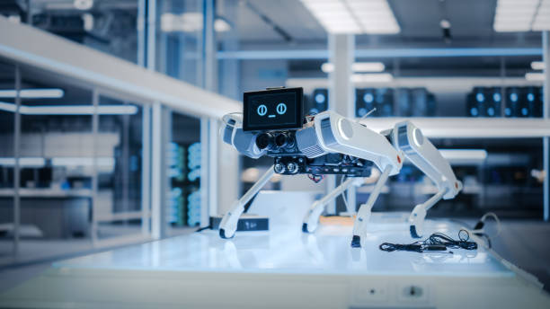 istock Robot Dog Prototype Standing in a High Tech Modern Industrial Facility. Mobile Robot with Lidars, Sensors, Optics, Computers, Cameras, Screen with Running Software Code and Smiling Emoji. 1482148805