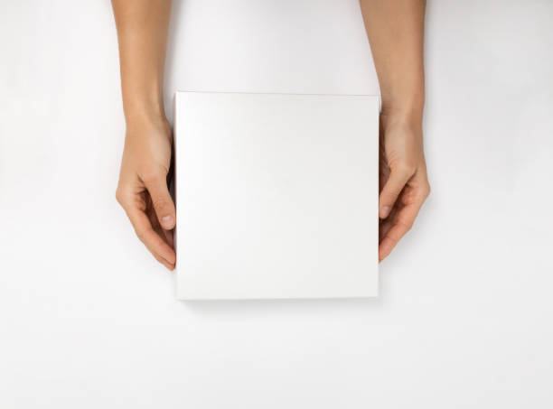 istock Mockup of white box on white background. Hands holding blank cardboard gift 1482149091