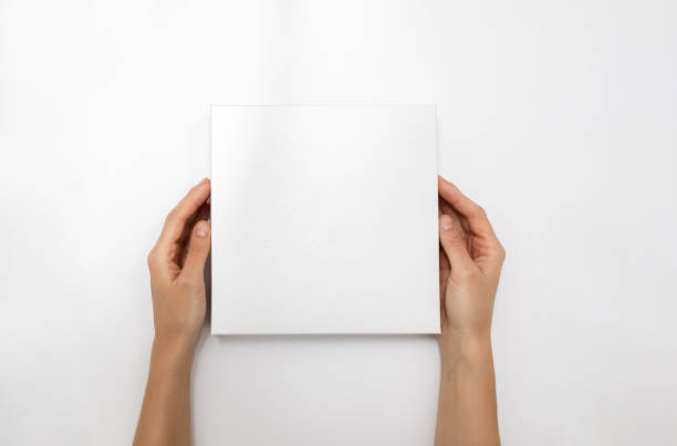 istock Mockup of white box on white background. Hands holding blank cardboard gift 1482149099