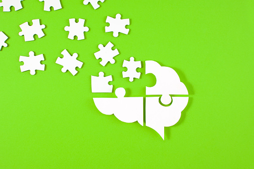 Brain shaped puzzle pieces on green colored background