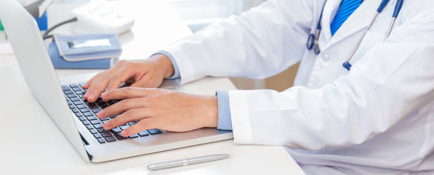 istock Close up man doctor hand typing on key board laptop computer, gadget on desk with copy space. Healthcare and medical worker people sickness hospital concept panoramic banner 1482149354