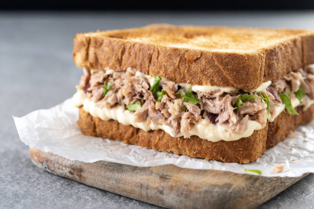 istock Tuna sandwich with mayo and vegetables on gray stone background. 1482150330