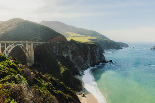 View of car on Bixby Creek bridge at scenic coastline of Big Sur, California Panoramic landscape of beautiful old bridge by the ocean between the mountains on Monterey peninsula, the USA Bixby Creek stock pictures, royalty-free photos & images