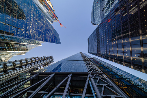 Highly detailed abstract wide angle view up towards the sky in the financial district of London City and its ultra modern contemporary buildings with unique architecture on a cloudy day. Including some iconic buildings at Lime street: Lloyd’s building, WTW (Willis Towers Watson, The Scalpel building, The Leadenhall building, The Aviva building, etc. Shot on Canon EOS R5 full frame with 10mm prime wide angle lens. Image is ideal for background with many concepts.