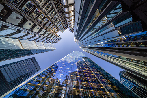 Highly detailed abstract wide angle view up towards the sky in the financial district of London City and its ultra modern contemporary buildings with unique architecture on a cloudy day. Including some iconic buildings at Lime street: Lloyd’s building, WTW (Willis Towers Watson, The Scalpel building, The Leadenhall building, The Aviva building, etc. Shot on Canon EOS R5 full frame with 10mm prime wide angle lens. Image is ideal for background with many concepts.