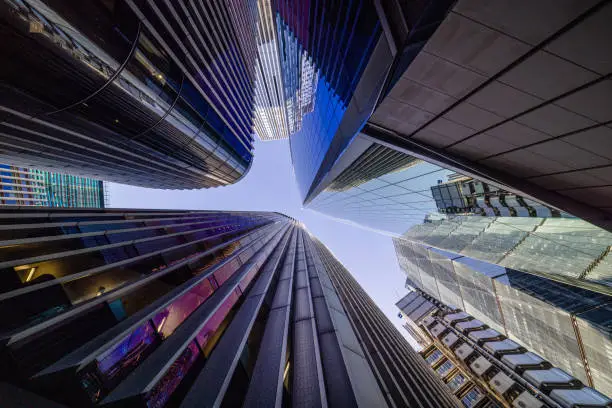 Highly detailed abstract wide angle view up towards the sky in the financial district of London City and its ultra modern contemporary buildings with unique architecture on a cloudy day. Including some iconic buildings at Lime street: Lloyd’s building, WTW (Willis Towers Watson, The Scalpel building, The Leadenhall building, The Aviva building, etc. Shot on Canon EOS R5 full frame with 10mm prime wide angle lens. Image is ideal for background with many concepts.