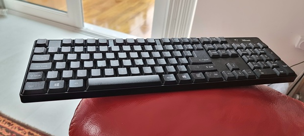 A used black keyboard. Wireless keyboard for computer or laptop.