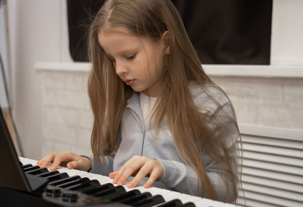 istock Cute serious girl playing the piano. Selective focus. Musical education, lesson. 1482152000