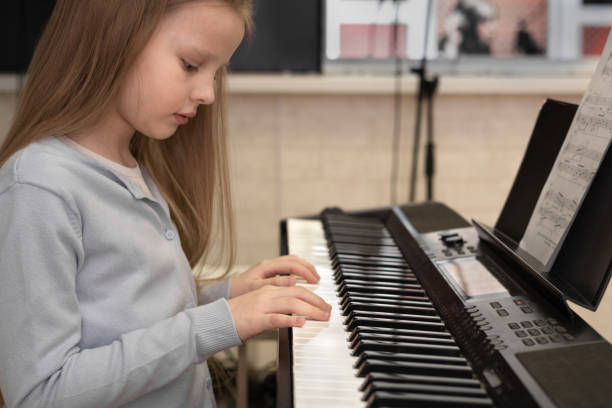 istock Cute serious girl playing the piano. Selective focus. Musical education, lesson. 1482152003