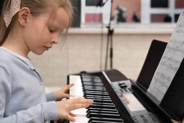 istock Cute serious girl playing the piano. Selective focus. Musical education, lesson. 1482152004