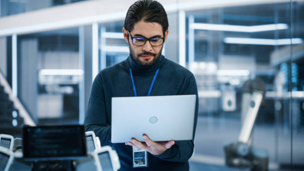 istock Handsome Hispanic Man Wearing Glasses Smiling and Looking at Camera. Young Intelligent Multiethnic Male Engineer, Developer or Scientist Working in Development Technology Office. 1482153415