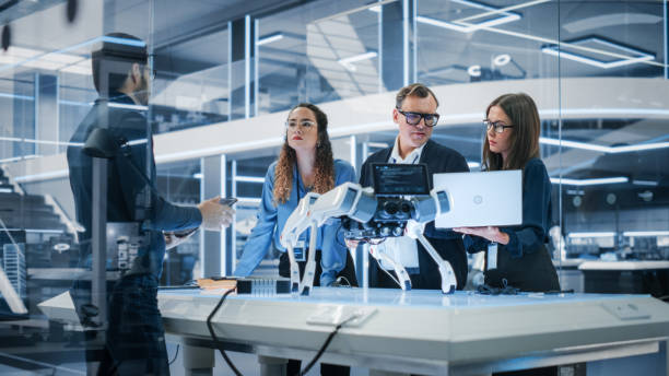 istock Professional Multicultural Team of Female and Male Engineers Use Industrial Programmable Robot Animal in a Factory Development Workshop. Tech Facility with Machines, Computers and Research Equipment. 1482153759