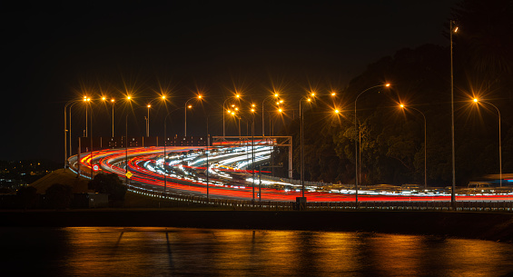 Long exposure image of car light trails on busy motorway. Evening rush hour traffic jam on motorway north of Harbour Bridge. Auckland.