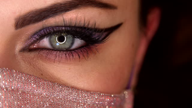 Woman in glamour facial mask. Macro eye blinking. Eyeshadows, false lashes