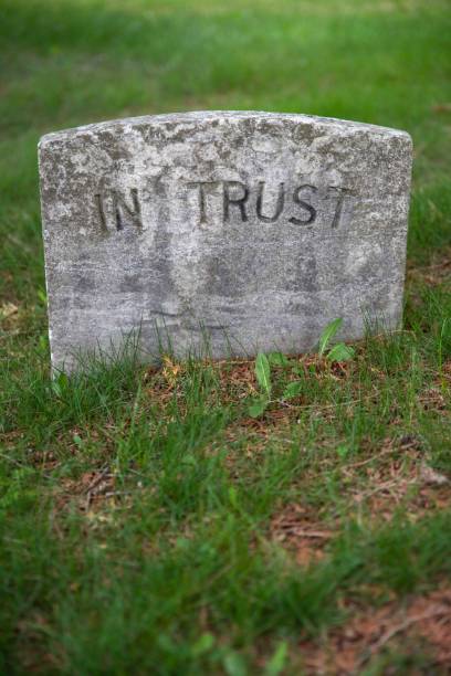 istock Vertical gravestone in green grass reads In Trust 1482160391
