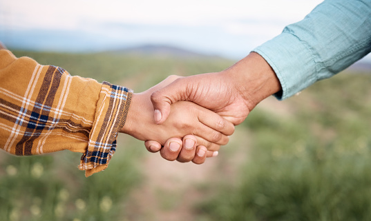 Deal, handshake and agriculture partnership at farm for sustainability teamwork, agreement or collaboration. Welcome, thank you and people, man and woman shaking hands for b2b, trust and support.