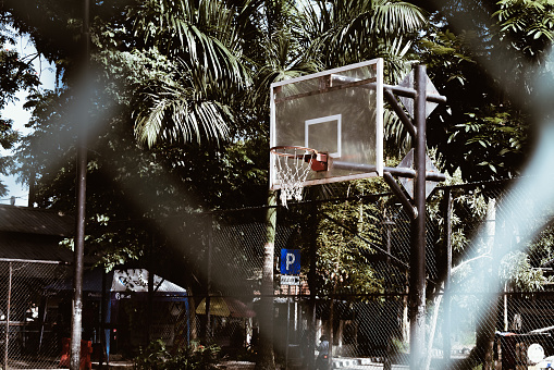 Basketball ball passing through hoop at outdoor court