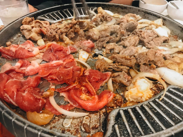 istock sliced raw beef and chicken meat roasting on the steel grating 1482165481