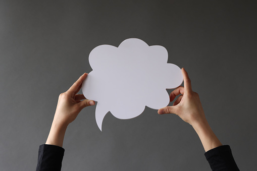 Blank colorful speech bubbles hanging from a cord over blue background