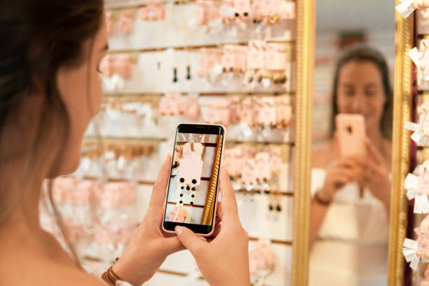 Customer photographs earrings on the shelf