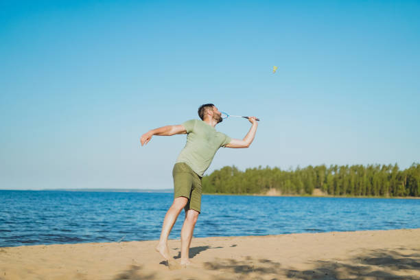 istock caucasian man playing badminton on the lakeside. 1482168590
