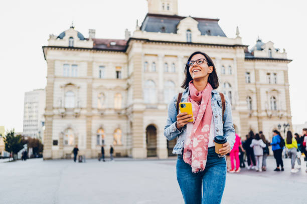 istock A woman walks around the city using a mobile phone 1482170096