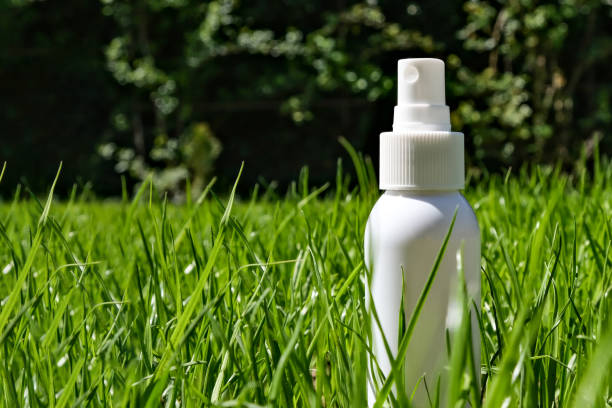 istock White plastic bottle with a dispenser on the background of green grass. Side view, space for text. 1482171519