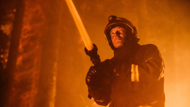 istock Experienced Firefighter Extinguishing a Wildland Brushfire Deep in the Forest. Professional Fireman in Safety Uniform and Helmet Spraying Water from Fire Hose to Battle Dangerous Wildfire. 1482174097