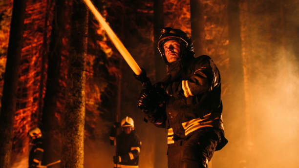 istock Group of Experienced Firefighters Extinguishing a Wildland Brushfire Deep in the Forest. Professional Fireman Wearing Safety Uniform, Spraying Water from Fire Hose to Battle Dangerous Wildfire. 1482174263
