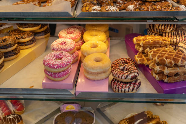 istock Donuts pattern. Showcase of a pastry shop with assorted glazed donuts and some waffles 1482179980