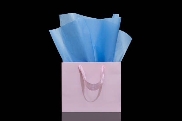 istock Craft paper gift bag with tissue paper isolated on a black background 1482180382