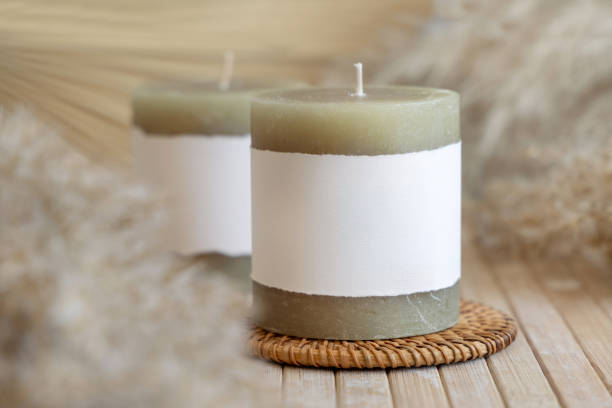 istock Candles with label on wooden table with dried pampas grass, Close up, copy space. Packaging mock up 1482183623