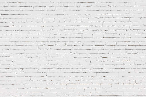 An old but freshly painted white brick wall.