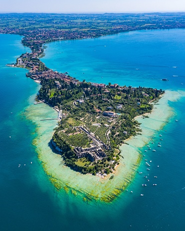 An aerial view of a stunning green island and blue sea. Sirmione, Italy.