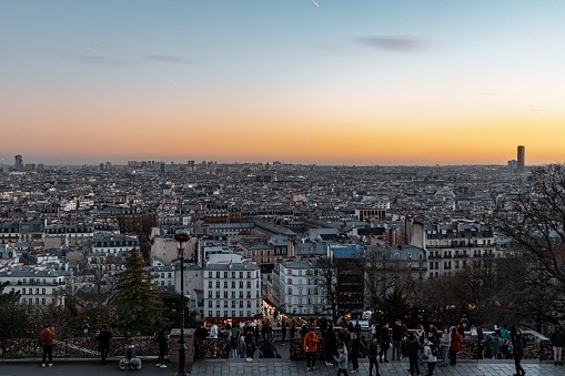 paris, France – February 02, 2023: A landscape of a park surrounded by buildings and people during the sunset in Paris, France