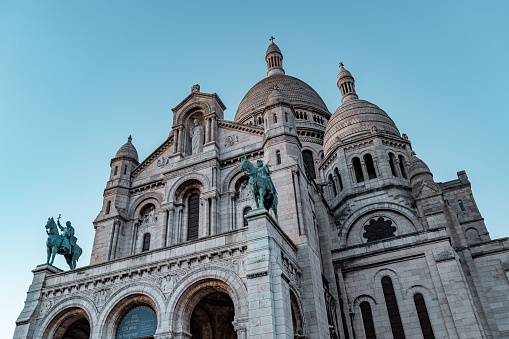 Paris, France – February 03, 2023: A low angle shot of The Basilica of the Sacred Heart of Paris under a blue sky in France
