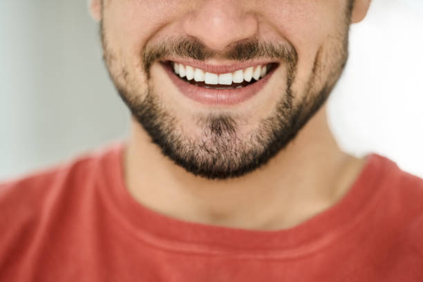 Close-up portrait of wide smiling male mouth with healthy clear white teeth