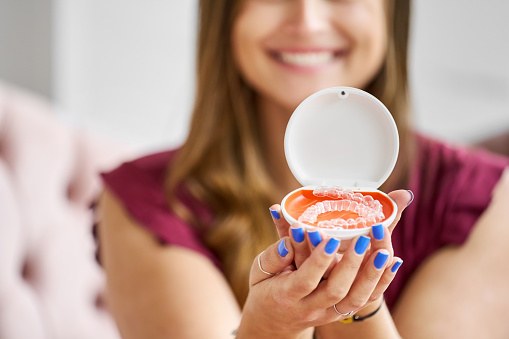 Close-up of invisible orthodontic retainers box in hands of a woman