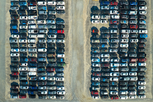 Aerial view of auction reseller company big parking lot with parked cars ready for remarketing services. Sales of secondhand vehicles.