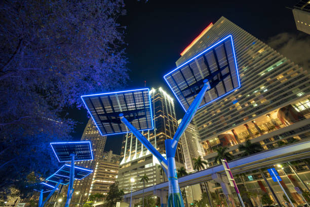 Modern urban street neon illumination with solar photovoltaic panels for power supply of streetlights and surveillance cameras. Futuristic energy source in downtown Miami, Florida Modern urban street neon illumination with solar photovoltaic panels for power supply of streetlights and surveillance cameras. Futuristic energy source in downtown Miami, Florida. solar street lights stock pictures, royalty-free photos & images