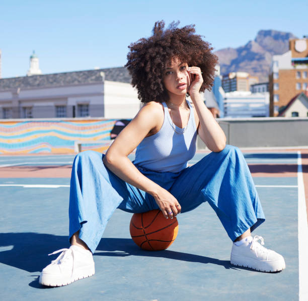 basket, moda e ritratto di donna nera sul pavimento del campo con stile alla moda, urbano e abiti spigolosi in città. modello sportivo, fitness e ragazza all'aperto con palla per libertà, energia e outfit cool - street style foto e immagini stock