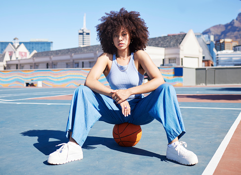 Fashion, city and portrait of black woman with basketball court with trendy, urban style and edgy clothes. Sports, fitness park and girl pose outdoors with ball for freedom, energy and confidence