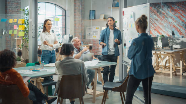 istock Latin Businessman Using Whiteboard and Mindmapping to Brainstorm with his Team in a Meeting Room in a Creative Office. Diverse Team Leads Consulting CEO on Best Strategies for Growth 1482199017