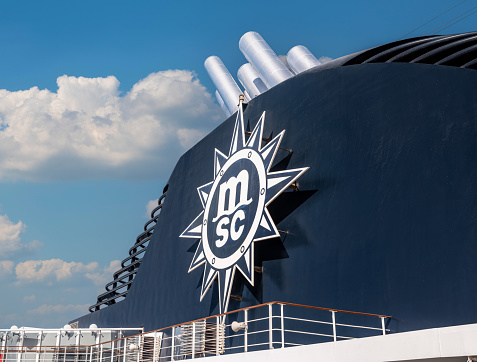 Dubai, United Arab Emirates - April 4, 2023: MSC logo on board cruise ship on blue sea background. MSC Cruises one of world's largest cruise lines